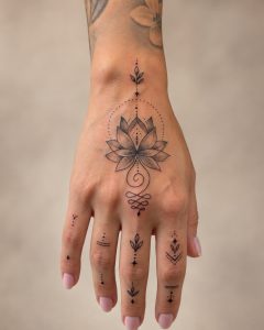 Fineline-Handtattoo mit Lotus und kleinen Fingersymbolen