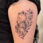 Löwin mit Jungtier und Blumen als Oberarm-Tattoo